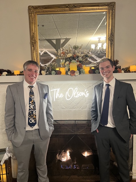 Myke and James in front of The Olson's sign