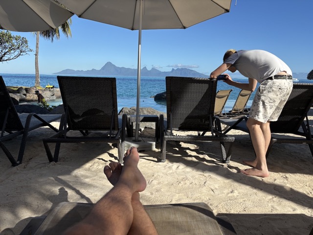 Relaxing at the pool while we wait for our room to be ready and James takes a photo