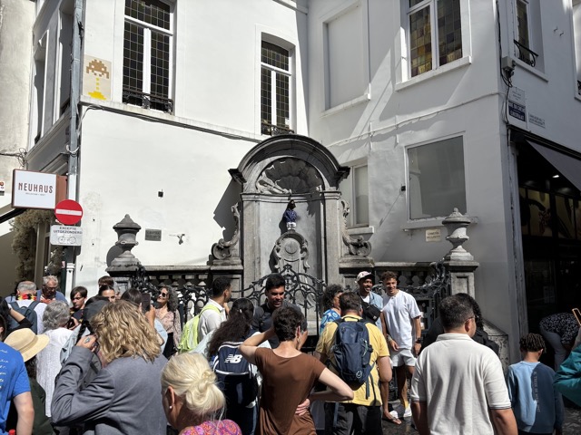 Manneken Pis, statue of a little boy peeing into the fountain.  Today he had on a little coat too