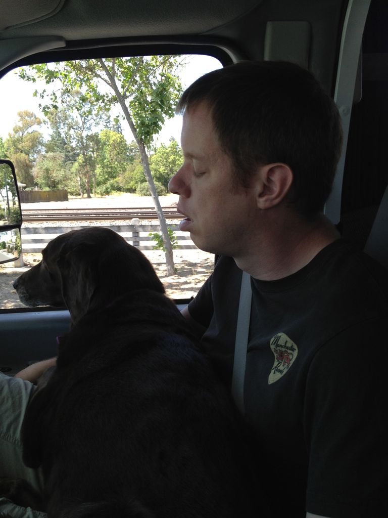 Rob asleep with Cadbury on his lap on the drive up